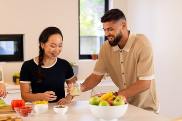 Wall Mural - Friends in kitchen, enjoying drinks and preparing healthy meal together