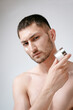 © Elina Leonova - Man using cream. Health care concept. SPA