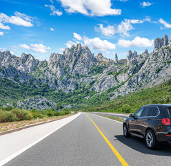 Wall Mural - The car is driving along the highway surrounded by picturesque nature.