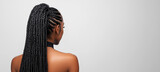 Close-up back view of a beautiful Black woman with long box braids in a ponytail against a white background
