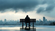 © Nano Photos - A solitary figure sits on a bench, overlooking a city skyline under a moody, overcast sky, creating a contemplative and melancholic atmosphere.