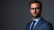 © Michael - Confident businessman in a suit and glasses poses for a studio portrait against a grey background