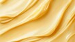 © Khalida - Closeup of yellow cream moisturizer smear on a beige background Wavy texture with copy space presented as a horizontal banner for skincare beauty product designs