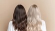 © Anna - Two women stand back to back, displaying their long, wavy hair in contrasting shades of brown and blonde against a simple light-colored background