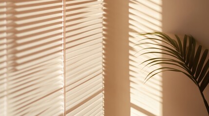 Poster - Sunlight filters through window blinds, casting soft shadows on a beige wall. A green plant adds a touch of nature to the warm and inviting space
