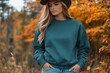 © MOUNSSIF - Portrait of a young woman wearing a crewneck blue mockup sweatshirt with fall colors and themed background for autumn season female fashion