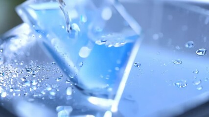 Poster - Captivating water droplets glimmering on a sleek surface with soft blue lighting