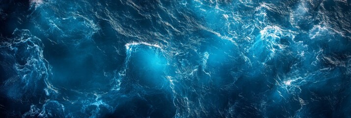 Top view of deep blue ocean water with waves and splashes in natural lighting