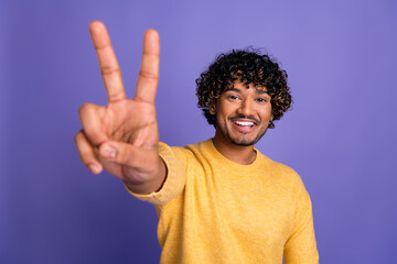 Sticker - Photo of positive funny man wear trendy yellow clothes v-sign gesture isolated on violet color background