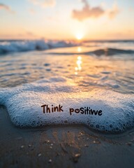 Sticker - The words 'Think Positive' are written on the sand of a beach at sunset.