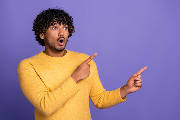 Poster - Photo of excited man wear trendy clothes demonstrate banner discount empty space isolated on violet color background