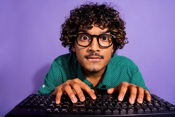 Poster - Closeup photo of arabian guy excited programmer looking in pc screen using keyboard wearing eyeglasses isolated on violet color background