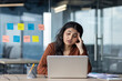 © Liubomir - Upset and sad woman reading email, businesswoman looking at laptop screen with hand on head, thinking and worried, female worker inside office at workplace.