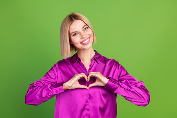 Canvas Print - Photo of pretty young woman show heart symbol wear purple shirt isolated on green color background