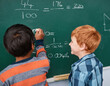 © FotoPush/peopleimages.com - Boys, writing and mathematics with chalkboard in classroom for education, learning or problem solving at school. Back view, kids or children with math equation, numbers or sum for answer or formula