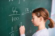 © FotoPush/peopleimages.com - Girl, writing and math with chalkboard for equation, education or learning in classroom at school. Female person, child or young kid with fraction, numbers or problem solving for answer or solution