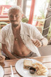 © Arkadi - Man eats and drinks mexican at the table in Mexico.