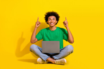 Canvas Print - Full length photo of cheerful positive guy dressed green t-shirt writing modern device showing up emtpy space isolated yellow color background