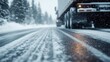 ©  lukaPixMedia - A close-up low angle view of a truck driving on a snow-covered road in a forested area during heavy snowfall, highlighting the challenging winter conditions.