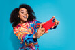© deagreez - Photo portrait of lovely young lady play excited mobile game dressed stylish colorful garment isolated on blue color background