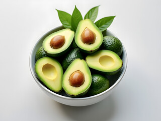 Freshly sliced avocados in a white bowl surrounded by whole avocados and green leaves in natural light