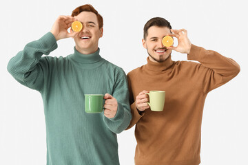 Sticker - Young men with cups of tea and lemons on white background