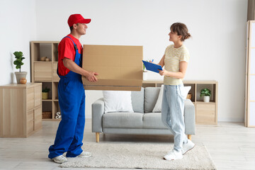 Wall Mural - Young woman receiving parcel from delivery man at home