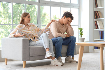 Sticker - Young woman with her upset husband sitting on sofa at sexologist's office