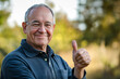© Rosemarie Mosteller - smiling senior citizen man wearing glasses with his thumb up for the concept of agreement and satisfaction with a choice