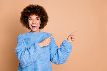 Wall Mural - Photo of impressed girl with chevelure dressed blue knit sweater directing at promo empty space isolated on pastel color background