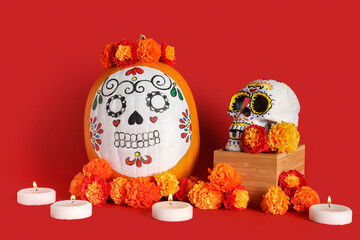 Canvas Print - Pumpkin with painted skull, burning candles and marigolds on red background. El Dia de Muertos