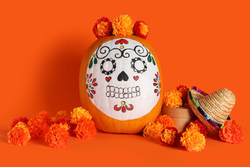 Sticker - Pumpkin with painted skull, beautiful marigold flowers and mini sombrero on orange background. El Dia de Muertos