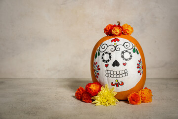 Canvas Print - Pumpkin with painted skull and beautiful flowers on light background. El Dia de Muertos