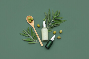 Wall Mural - Composition with bottles of essential oil, green olives and branches on color background