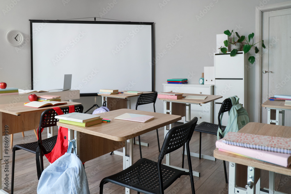 Interior of classroom with school desks and projector screen