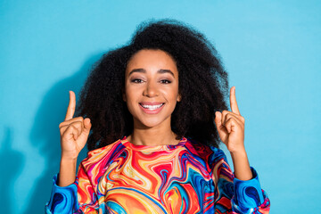 Poster - Photo of beautiful curly hair woman in trendy sweatshirt fingers pointing above head empty blank space isolated on blue color background