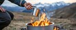© Kankamol Tama - Survivalist boiling contaminated water over a high-altitude fire, camping survival, purifying water at elevation