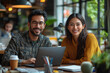 © Vertigo Images - Smiling man and woman working together on laptop in a cafe.