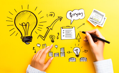 Wall Mural - igniting innovation: hands sketch a vibrant blueprint for success on a yellow backdrop, with a glowi