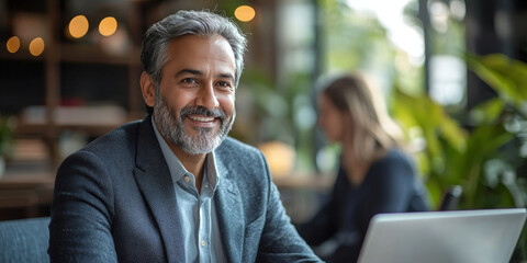 Canvas Print - Smiling businessman working on his laptop.