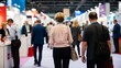 © Viewvie - Blurred rear view of people browsing booths at an exhibition.