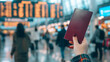 © พงศ์พล วันดี - Hand holding passport at busy airport terminal, people in background