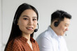 © Liubomir - Asian customer service representatives focused on providing excellent support in office environment. Headset communication for efficient service. Teamwork and professionalism emphasized in workplace