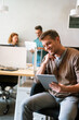 © NDABCREATIVITY - Group of young multi-ethnic startup business team collaborating on project in modern office