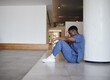 © peopleimages.com - Sad, doctor and black man on floor at hospital for medical mistake, depression and anxiety of burnout. Healthcare, relax and grief with stress from surgery news, mental health and emergency crisis