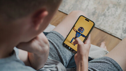 Poster - teen boy scrolls through and watches social network feed with short videos using mobile phone while 