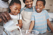 © peopleimages.com - Baking, milk and black family in kitchen for bonding, learning and skill development in home. Mixing bowl, ingredients and African parents teaching children to cook for growth and fun at house.