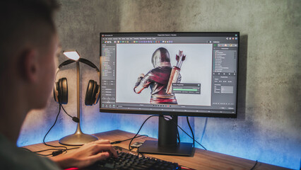 Fototapete - Young designer creates 3D model of game character using PC. Interface of professional 3D modeling software. Teenage boy working on freelance project on computer at home. Game development concept.
