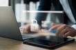© Thapana_Studio - Cyber ​​network security and data protection on the internet, businessman using security encryption of laptop and tablet with padlock icon, protecting sensitive business and financial information.
