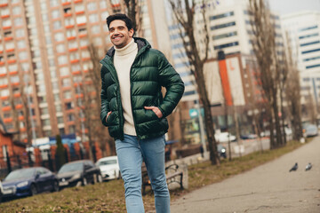 Photo of smiling cheerful young man wearing stylish clothes going work park street cold autumn outdoors